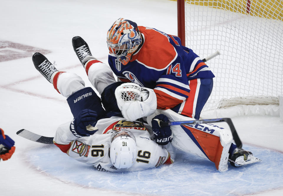 Florida Panthers' Aleksander Barkov (16) crashes into Edmonton Oilers goalie Stuart Skinner (74) during the second period of Game 6 of the NHL hockey Stanley Cup Final, Friday, June 21, 2024, in Edmonton, Alberta. (Jeff McIntosh/The Canadian Press via AP)