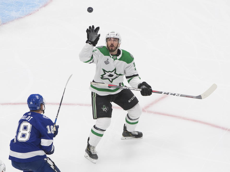 Dallas Stars defenseman Joel Hanley (39) grabs for the puck as Tampa Bay Lightning left wing Ondrej Palat (18) skates in during the third period of Game 5 of the NHL hockey Stanley Cup Final, Saturday, Sept. 26, 2020, in Edmonton, Alberta. (Jason Franson/The Canadian Press via AP)