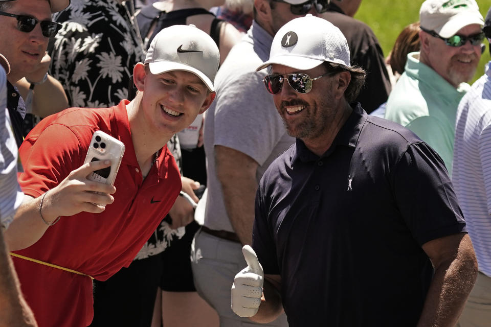 Phil Mickelson poses for a photo with a fan during a practice round ahead of the U.S. Open golf tournament, Tuesday, June 14, 2022, at The Country Club in Brookline, Mass. (AP Photo/Charlie Riedel)