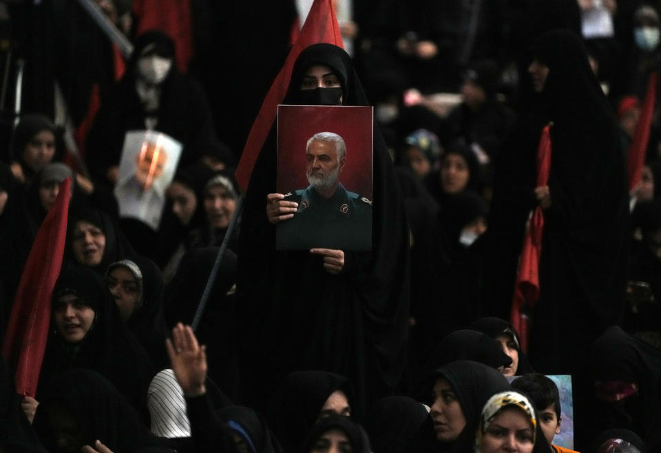 A woman holds up a poster of the late Revolutionary Guard Gen. Qassem Soleimani, who was killed in a U.S. drone attack in 2020 in Iraq, during a commemoration for him at the Imam Khomeini grand mosque in Tehran, Iran, Wednesday, Jan. 3, 2024. Two bombs exploded Wednesday at a commemoration for a prominent Iranian general slain by the U.S. in a 2020 drone strike, Iranian officials said, as the Middle East remains on edge over Israel's war on Hamas in the Gaza Strip. (AP Photo/Vahid Salemi)