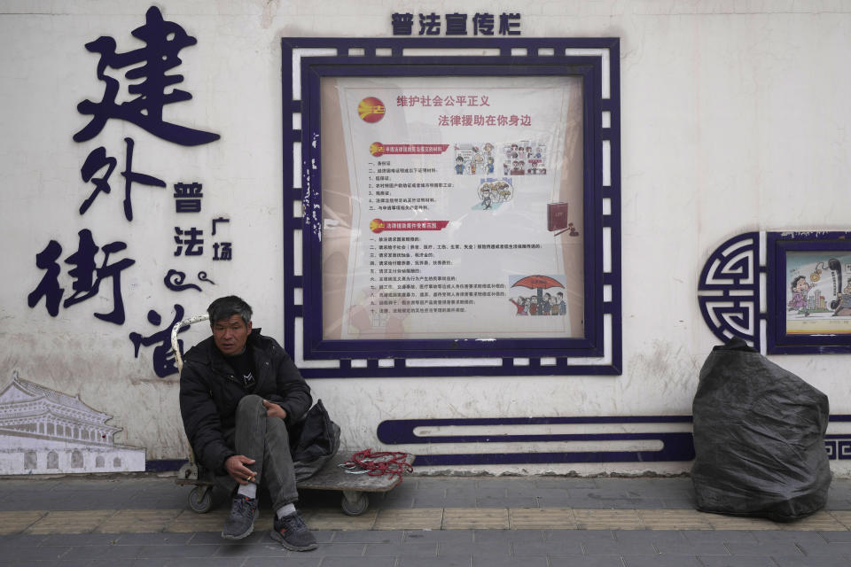 A worker sits on a street in Beijing, China, March 21, 2024. China’s first generation of migrant workers played an integral role in the country's transformation from an impoverished nation to an economic powerhouse. Now, they're finding it hard to find work, both because they're older and the economy is slowing. (AP Photo/Tatan Syuflana)