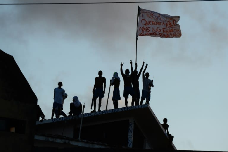 Prisioners atop the roof of the compound celebrate the transfer of their leaders after a negotiation with the police at the Alcacuz Penitentiary, near Natal, on January 16, 2017