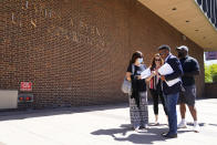 Former NFL players Clarence Vaughn III, right, Ken Jenkins, second right, along with their wives, Brooke Vaughn, third right, and Amy Lewis, carrie tens of thousands of petitions demanding equal treatment for everyone involved in the settlement of concussion claims against the NFL, to the federal courthouse in Philadelphia, Friday, May 14, 2021. Thousands of retired Black professional football players, their families and supporters are demanding an end to the controversial use of “race-norming” to determine which players are eligible for payouts in the NFL’s $1 billion settlement of brain injury claims, a system experts say is discriminatory. (AP Photo/Matt Rourke)