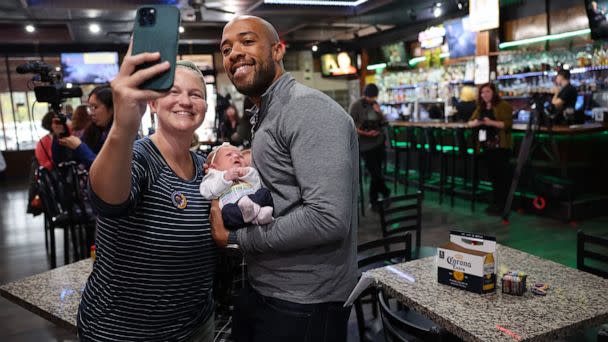 PHOTO: Democratic candidate for U.S. senate in Wisconsin Mandela Barnes poses for a picture with Mandi Miller and her 3-week-old daughter Lark during a campaign stop in West Allis, Wisc., Oct. 12, 2022. (Scott Olson/Getty Images)