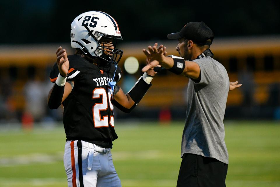 Beaver Falls' quarterback Da'Sean Anderson talks with coach Nick Nardone  during Friday's game against Blackhawk at Reeves Field at Geneva College.