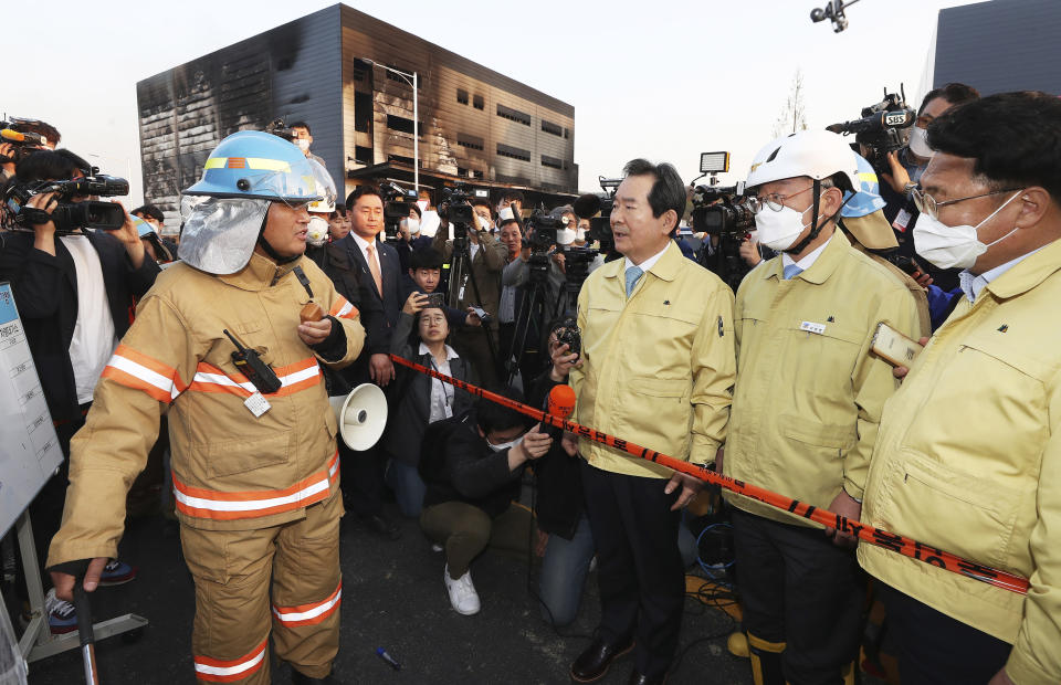 South Korean Prime Minister Chung Se-kyun, third from right, is briefed from a firefighter on details of a fire at a construction site in Icheon, South Korea, Wednesday, April 29, 2020. One of the South Korea’s worst fires in years broke out at the construction site. (Hong Ki-won/Yonhap via AP)