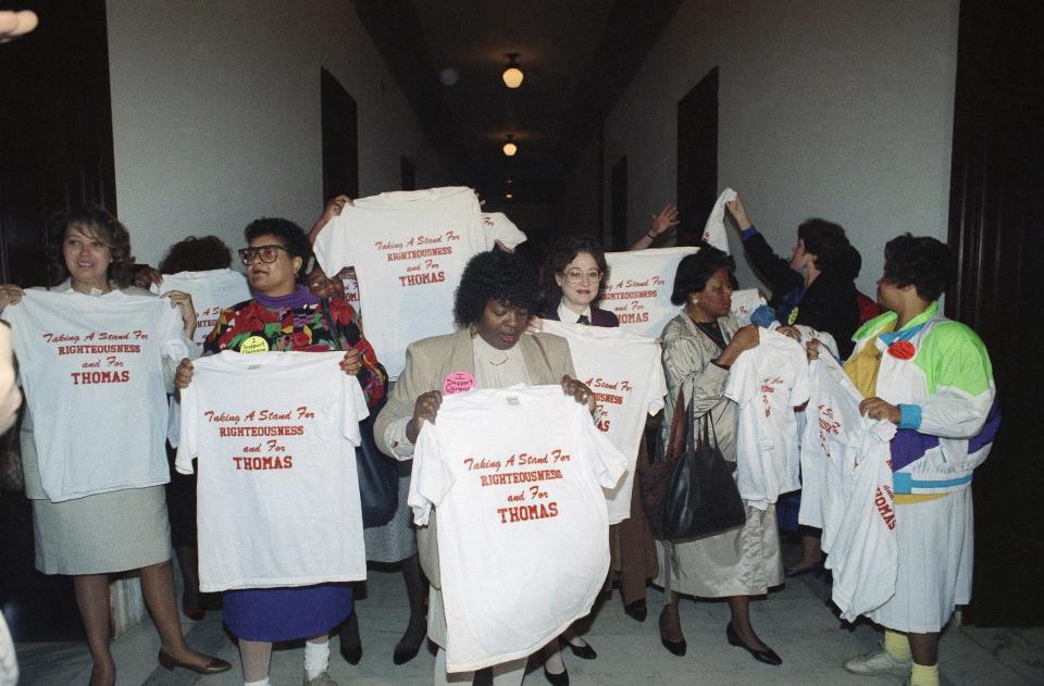 Women holding t-shirts that show their support for Clarence Thomas’ nomination in 1991.