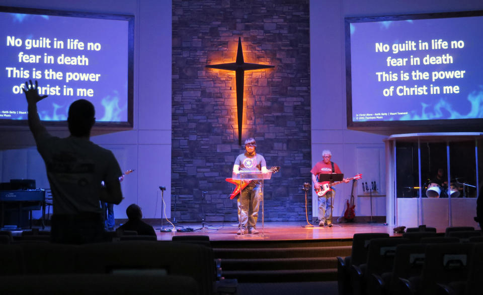 In this April 17, 2014 photo 19-year-old Texan John David, left, raises his arm during a song at Cornerstone First Baptist Church in Williston, N.D. When the oil and gas boom took off, tens of thousands of workers flocked to the oil fields for jobs. Missionaries soon followed. (AP Photo/Josh Wood)