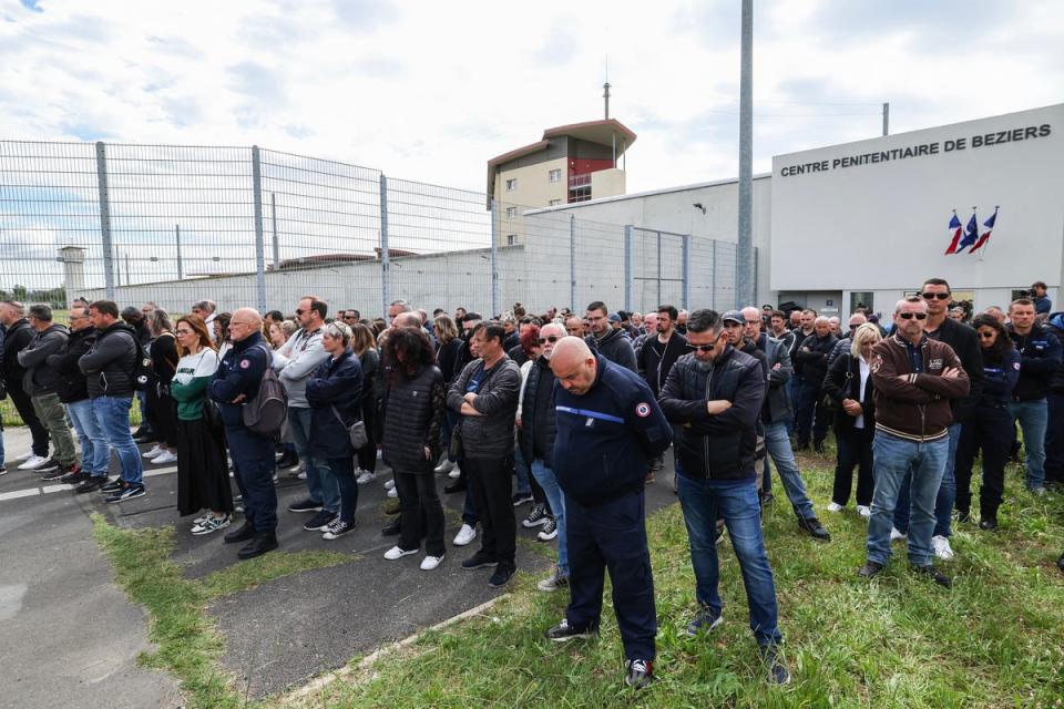 Prison officers observe a minute of silence as they gather at the entrance of a jail in Beziers, southern France (AFP via Getty Images)