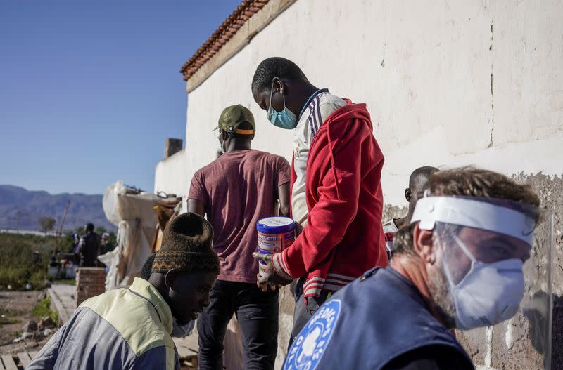 Miembros de ONG Médicos del Mundo distribuyen alimentos a migrantes de Malí en San Isidro, durante el brote de la enfermedad por coronavirus (COVID-19) en Níjar, en la región de Almería