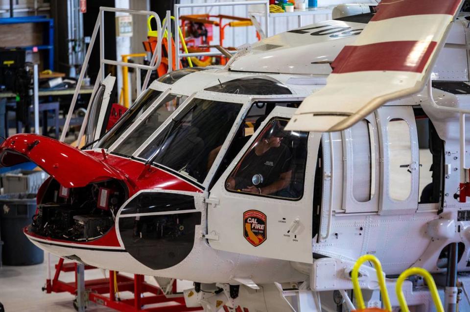 Mechanic assesses Cal Fire Hawk firefighting helicopter for routine maintenance check at Cal Fire McClellan Reload Base in McClellan on June 25.