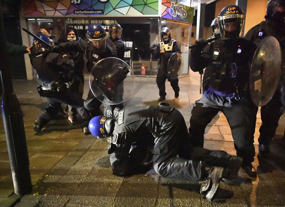 Police officers detain a man as they move in on demonstrators during the "Kill The Bill" protest, in Bristol, England, Friday, March 26, 2021. Protesters are calling to protect free speech and protesting against new powers to be given to the police to impose conditions on non-violent protests, including those deemed too noisy or a nuisance. (Ben Birchall/PA via AP)