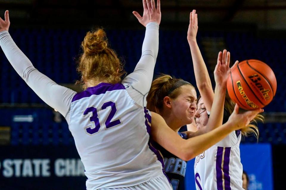 Rogers guard Sydney Kowalchuk (14) attempts to squeeze throw Lake Stevens forward Cori Wilcox (32) and guard Ella Edens (0) as she attempts a layup during the fourth quarter of a Class 4A state tournament game on Wednesday, March 2, 2022, at the Tacoma Dome, in Tacoma, Wash.