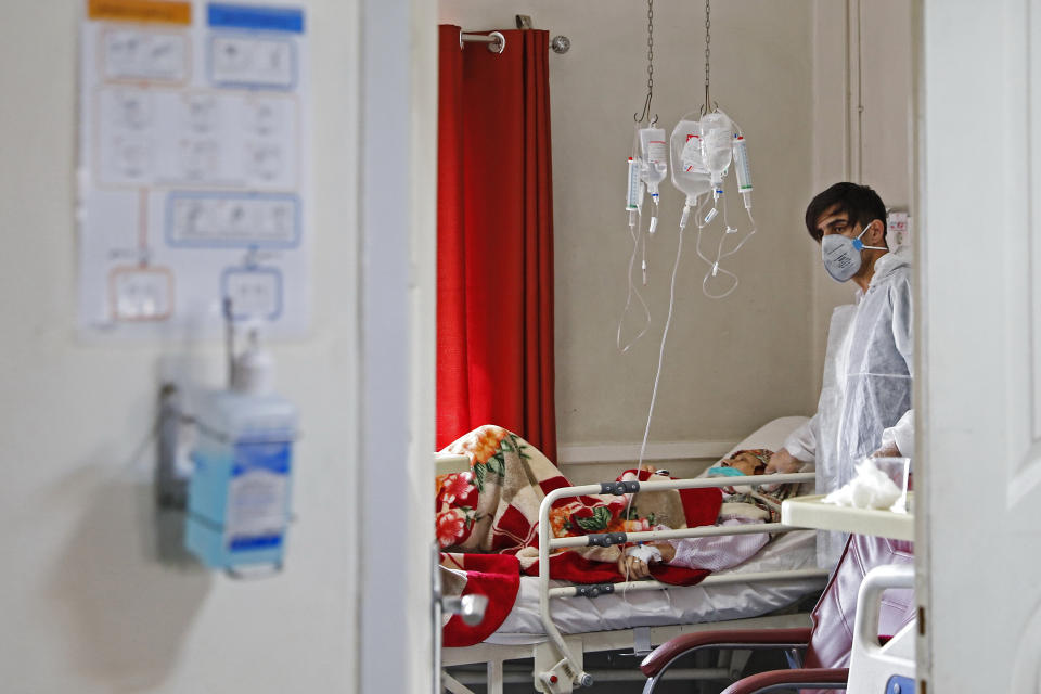 In this Sunday, March 1, 2020 photo, a medic treats a patient infected with coronavirus, at a hospital in Tehran, Iran. A member of a council that advises Iran's supreme leader died Monday after falling sick from the new coronavirus, becoming the first top official to succumb to the illness striking both citizens and leaders of the Islamic Republic. (Ali Shirband/Mizan News Agency via AP)