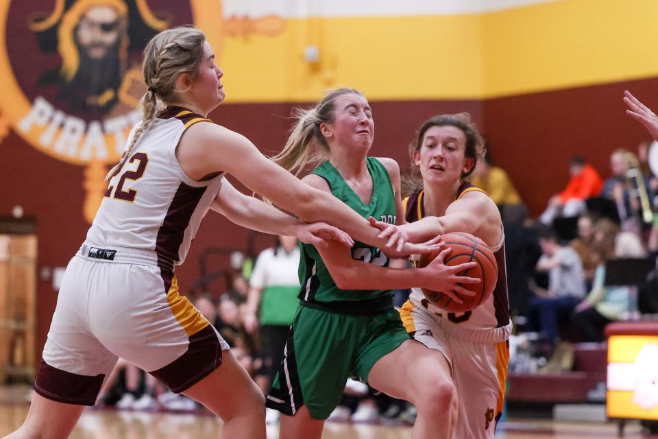 Mogadore junior guard Brook McIntyre drives through a pair of Pirates defenders to the basket during Wednesday night’s game at Southeast High School.