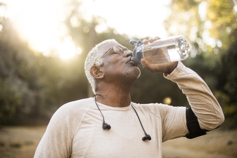 Man drinking water after suffering from heat exhaustion. (Getty Images)