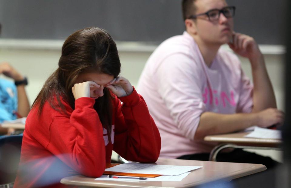 Michelle Pindrik, a junior, rubs her face to stay awake during teacher Rich Schram's eighth period honors physics class Aug. 28, 2014 at Buffalo Grove High School in Buffalo Grove, Ill.