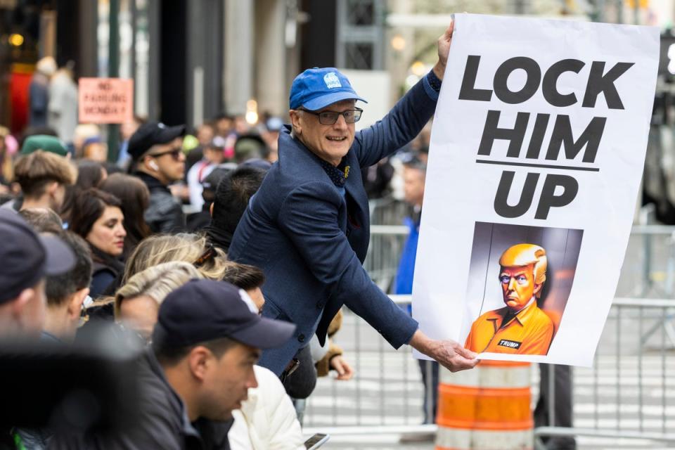 In a twist on Donald Trump’s old 2016 campaign slogan, protesters outside Trump Towers called for the ex-president to be locked up on Monday (Associated Press)