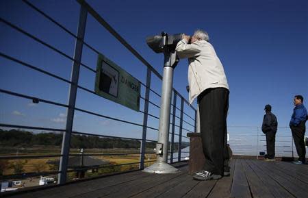 A man looks towards the north through a pair of binoculars at the Imjingak pavilion near the demilitarized zone which separates the two Koreas, in Paju, north of Seoul October 16, 2013. REUTERS/Kim Hong-Ji