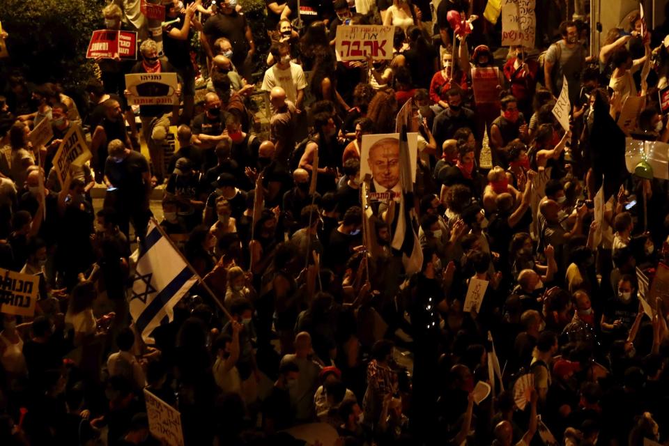 Thousands of demonstrators chant slogans and hold signs during a protest against Israel's Prime Minister Benjamin Netanyahu outside his residence in Jerusalem, Saturday, July 25, 2020. Protesters demanded that the embattled leader resign as he faces a trial on corruption charges and grapples with a deepening coronavirus crisis. (AP Photo/Ariel Schalit)