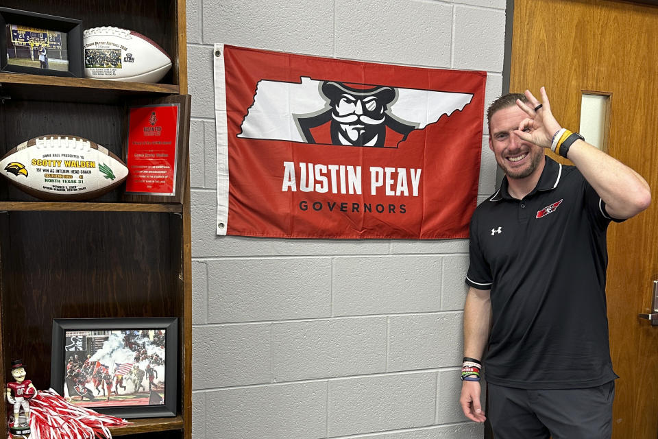 Austin Peay NCAA college football head coach Scotty Walden makes the schools "Monocles Up" sign as he poses in the football offices in Clarksville, Tenn., Oct. 24, 2023. Xavier Smith was excited about the prospect of playing for Deion Sanders. He didn't get a chance after some 50 Colorado players were cut after spring practice to make room for a flood of transfers. Smith landed at Austin Peay. (AP Photo/Teresa Walker)