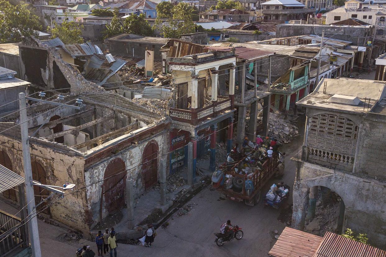 A truck drives past a collapsed building in Jeremie, Haiti, Wednesday, Aug. 18, 2021, four days after the city was struck by a 7.2-magnitude earthquake.