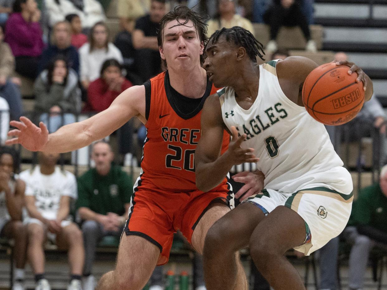 Green's Brady Rollyson (20) defends GlenOak's Ja'Corey Lipkins (0) during a boys basketball game at GlenOak on Tuesday, January 9, 2024.