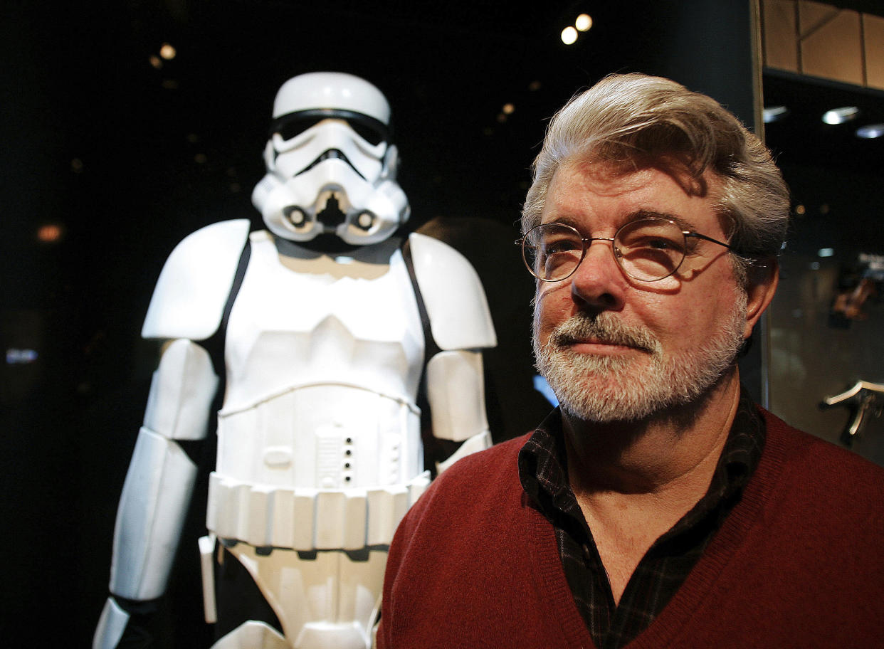 FILE – In this Oct. 22, 2005 file photo, filmmaker George Lucas poses in front of a Stormtrooper exhibit at the Museum of Science in Boston, prior to the opening of “Star Wars: Where Science Meets Imagination.”(AP Photo/Winslow Townson, File)