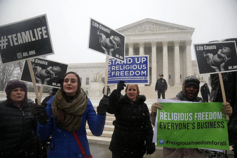 Demonstrators participate in a rally in front of the Supreme Court in Washington, Tuesday, March 25, 2014, as the court heard oral arguments in the challenges of President Barack Obama's health care law requirement that businesses provide their female employees with health insurance that includes access to contraceptives. Supreme Court justices are weighing whether corporations have religious rights that exempt them from part of the new health care law that requires coverage of birth control for employees at no extra charge. (AP Photo/Charles Dharapak)