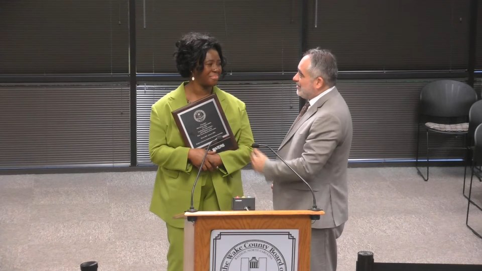 Former Wake County school board member Tara Waters receives a plaque from school board chair Chris Heagarty in Cary, N.C., on Jan. 9, 2024, for her service on the board. Wake County Public Schools