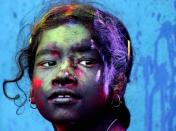 A girl, color smeared on her face, looks on during "Holi" celebrations in Calcutta, India, Saturday, March 3, 2007. Holi, the Hindu festival of colors, also heralds the coming of spring. (AP Photo/Sucheta Das)