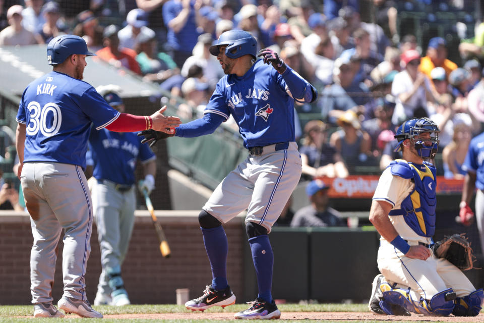 Toronto Blue Jays' George Springer, center, celebrates with Alejandro Kirk (30) after hitting a three-RBI home run as Seattle Mariners catcher Cal Raleigh, right, looks on during the seventh inning of a baseball game, Sunday, July 7, 2024, in Seattle. (AP Photo/Jason Redmond)