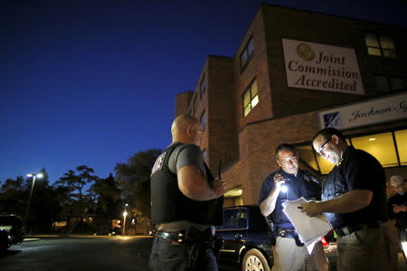 Cook County Sheriff police officers gather in a parking lot to go over paperwork before going out to serve outstanding arrest warrants in the Austin neighborhood in Chicago, Illinois, United States, September 9, 2015. REUTERS/Jim Young