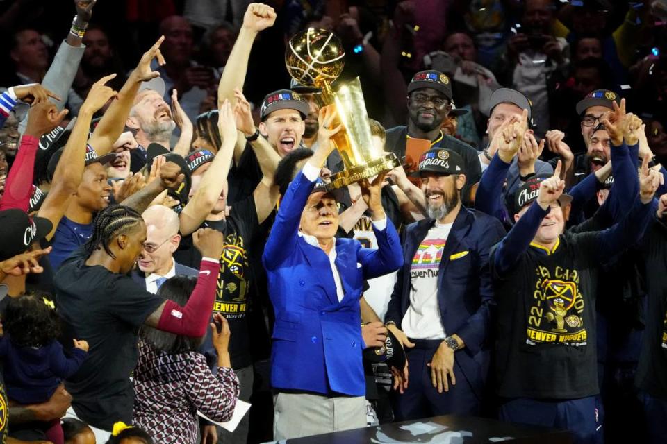 El dueño de los Nuggets Stan Kroenke levanta el trofeo de campeón que su equipo logró al vencer al Heat de Miami en el quinto partido de las Finales de la NBA, celebrado el lunes 12 de junio de 2023 en Denver.