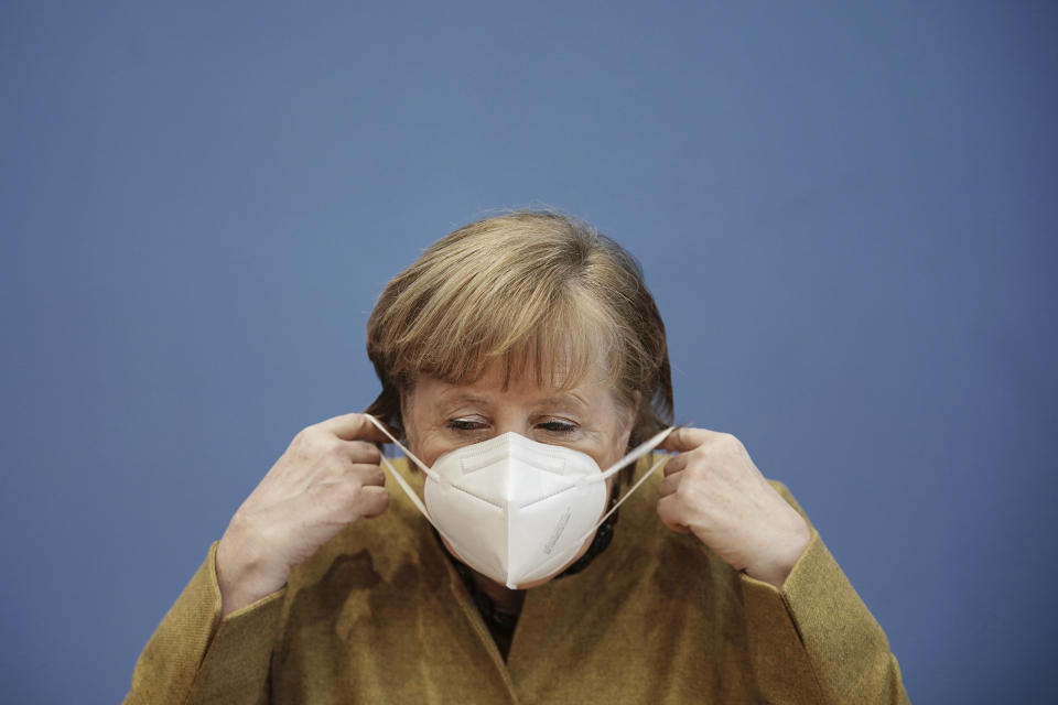 German Chancellor Angela Merkel arrives wearing a protective mask for a press conference on the current situation in Berlin, Germany, Thursday, Jan. 21, 2021. Topics include the decisions taken by the federal and state governments to combat the Corona pandemic, the Chancellor's upcoming virtual consultations with the heads of state and government of the European Union (EU), and relations with the United States following the inauguration of the new president. (Michael Kappeler/Pool via AP)