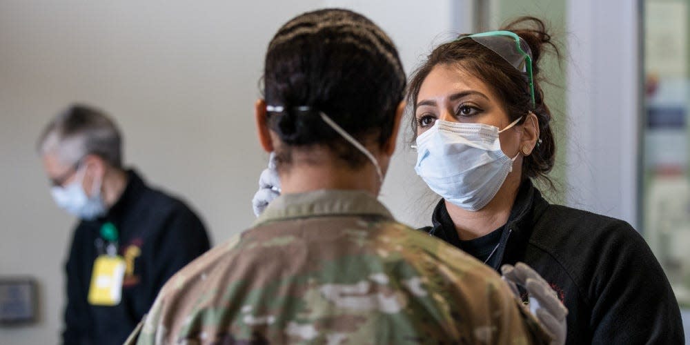 Krystal Moore, LPN, takes the temperature of a Soldier during a secondary screening on Tuesday, March 24, at Madigan Army Medical Center's Winder Clinic on Joint Base Lewis-McChord in Tacoma, Wash.