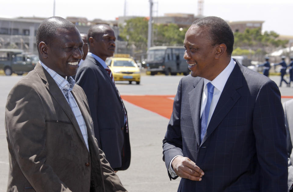 In this photo released by the Kenya Presidency, Kenyan President Uhuru Kenyatta, right, and Deputy President William Ruto, left, chat after arriving back from the African Union (AU) summit in Addis Ababa, at the airport in Nairobi, Kenya, Saturday, Feb. 1, 2014. The African Union urged its members to "speak with one voice" against criminal proceedings at the International Criminal Court against sitting presidents, according to a statement Saturday, saying it was disappointed that a request to the U.N. Security Council to defer the trials of Kenya's leaders "has not yielded the positive result expected." (AP Photo/Kenya Presidency)