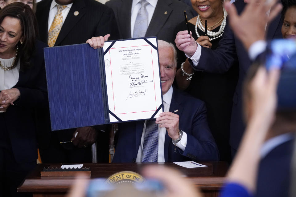 President Joe Biden holds the Juneteenth National Independence Day Act after signing it in the East Room of the White House, Thursday, June 17, 2021, in Washington. (AP Photo/Evan Vucci)