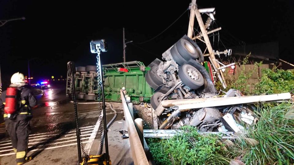 一輛載運醋酸的化學槽車5日上午4時55分行經新北市貢寮區台2線約92公里處時撞到電線桿不慎翻覆，槽車跌落邊坡車頭變形，司機受困車內，目前仍在搶救中。(中央社/新北消防局提供)