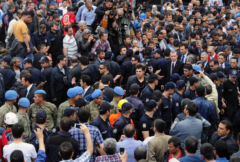Turkey's Prime Minister Recep Tayyip Erdogan, center right, is surrounded by security members as he visits the coal mine in Soma, Turkey, Wednesday, May 14, 2014. An explosion and fire at the coal mine killed at least 232 workers, authorities said, in one of the worst mining disasters in Turkish history. Turkey's Energy Minister Taner Yildiz said 787 people were inside the coal mine at the time of the accident. (AP Photo/Emre Tazegul)