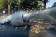 <p>A protester is hit in the face with a water cannon outside of the gates of the ZImbabwe Electoral Commission (ZEC) during a protest against polling results in Harare, Zimbabwe, 01 August 2018. The day saw protests turn violent when police fired rubber bullets and teargas, before the army was called in and began firing live rounds. (Photo: Yeshiel Panchia/EPA-EFE/REX/Shutterstock) </p>