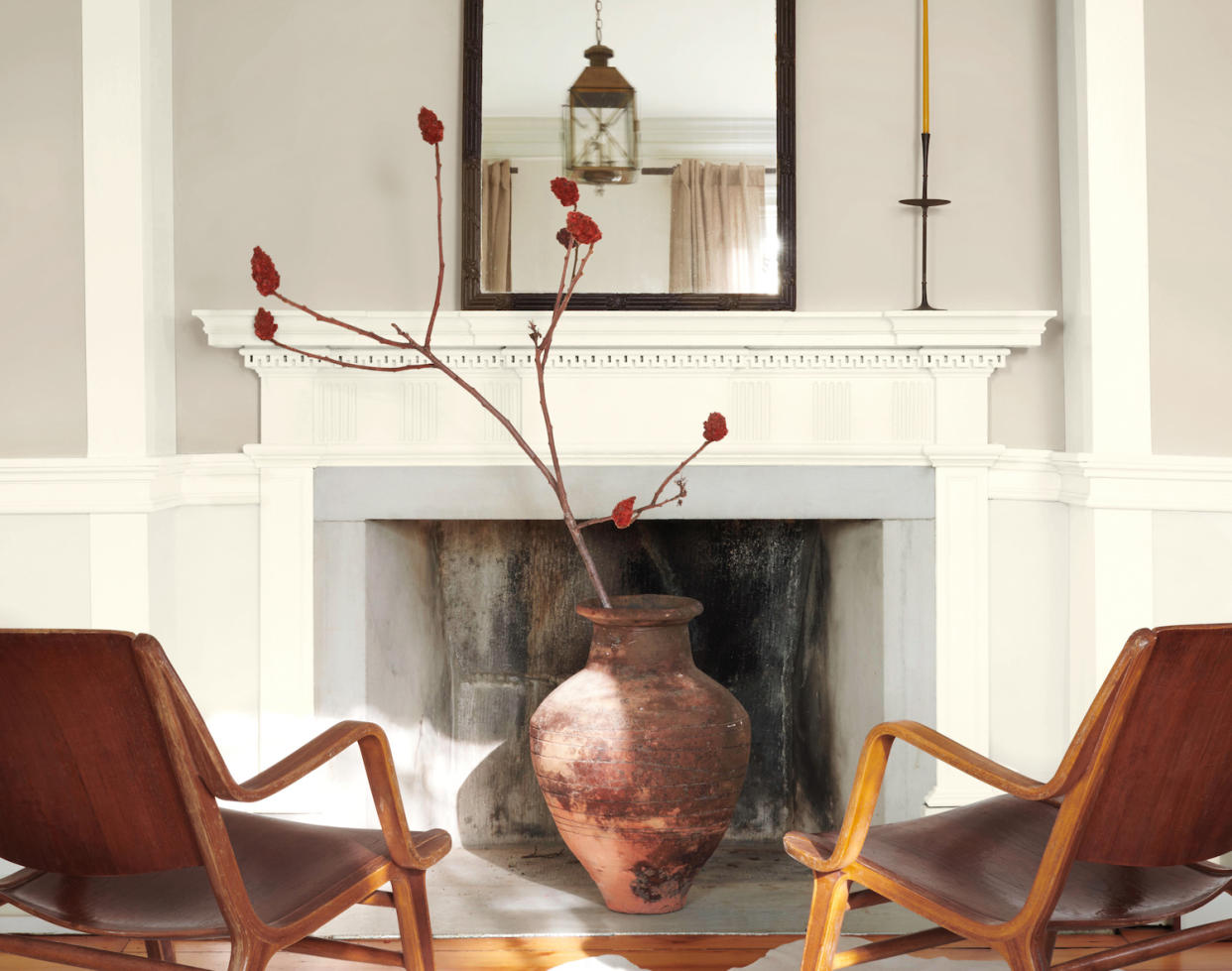  A living room with grey walls and white trim plus two leather armchairs. 