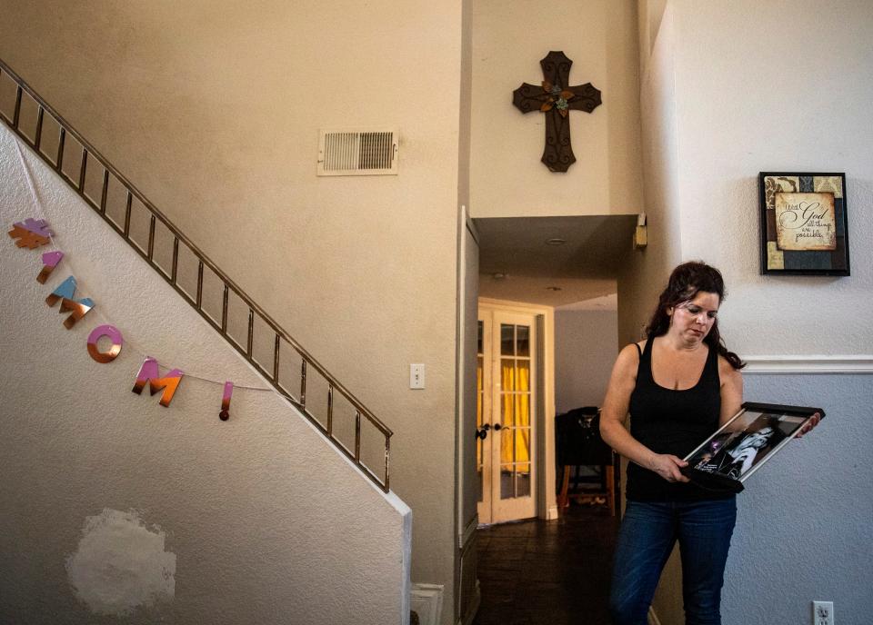 Kathy Nigro poses with a photo of her son, Michael Vasquez, at her home in Menifee on Wednesday.