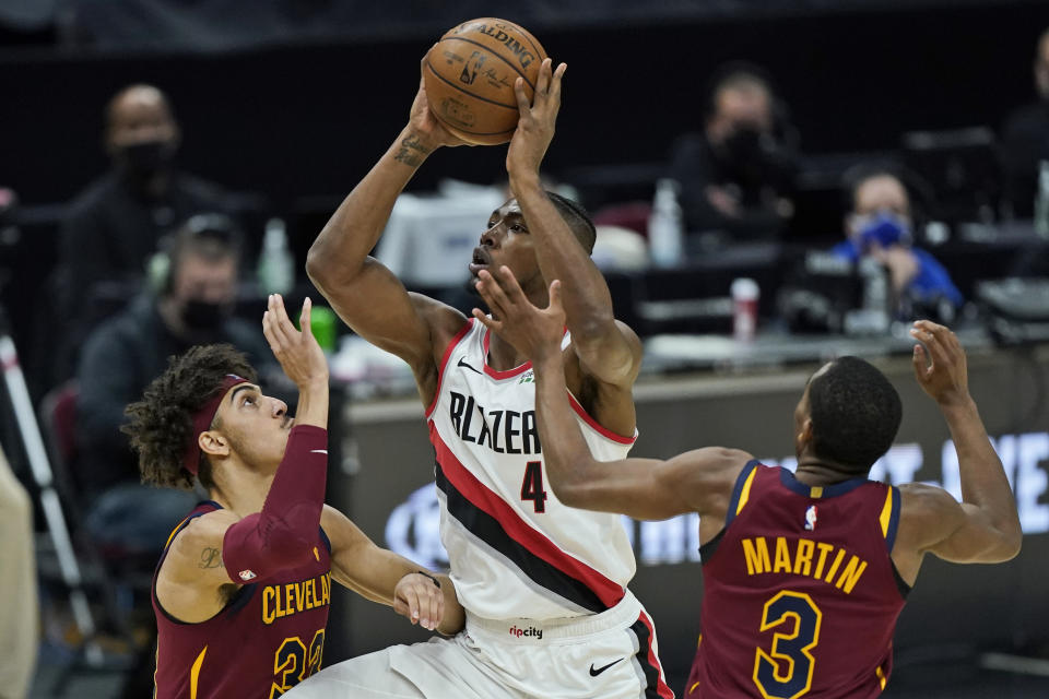 Portland Trail Blazers' Harry Giles III (4) drives to the basket against Cleveland Cavaliers' Brodric Thomas (33) and Jeremiah Martin (3) during the second half of an NBA basketball game, Wednesday, May 5, 2021, in Cleveland. Portland won 141-105. (AP Photo/Tony Dejak)