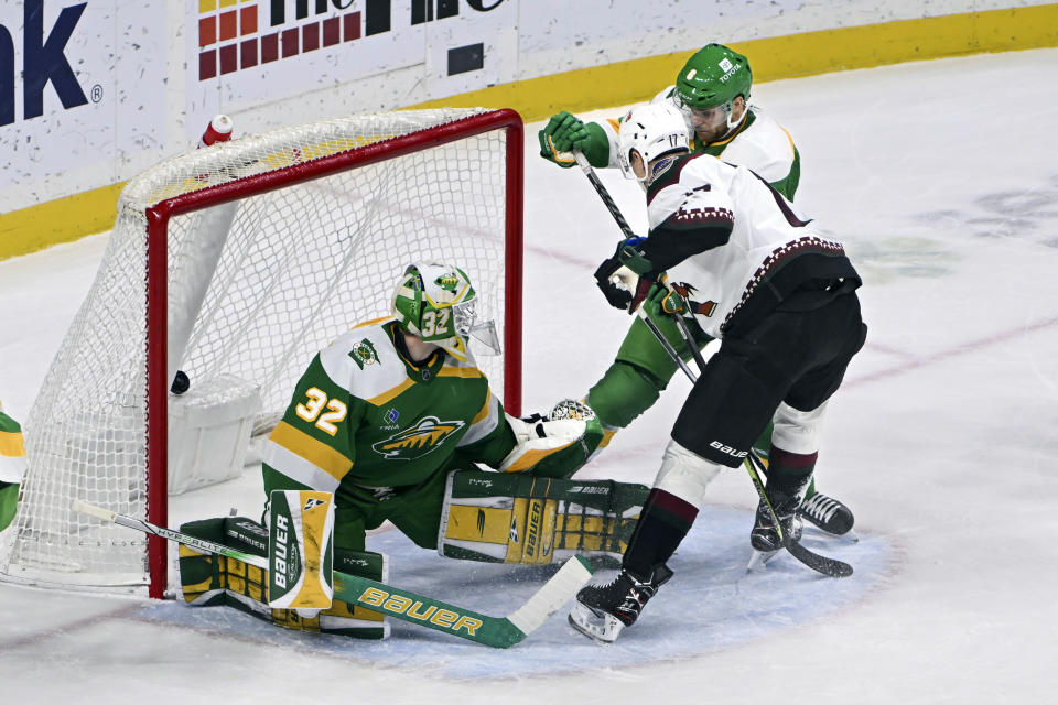 Arizona Coyotes center Nick Bjugstad, right, hits the puck past Minnesota Wild goalie Filip Gustavsson (32) and defenseman Dakota Mermis to score during the first period of an NHL hockey game Saturday, Jan. 13, 2024, in St. Paul, Minn. (AP Photo/Craig Lassig)