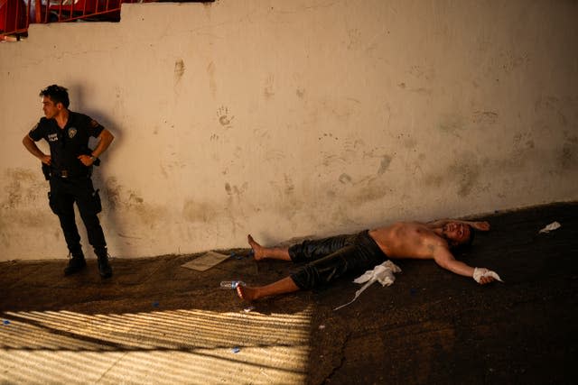 An exhausted wrestler lies on the ground after competing