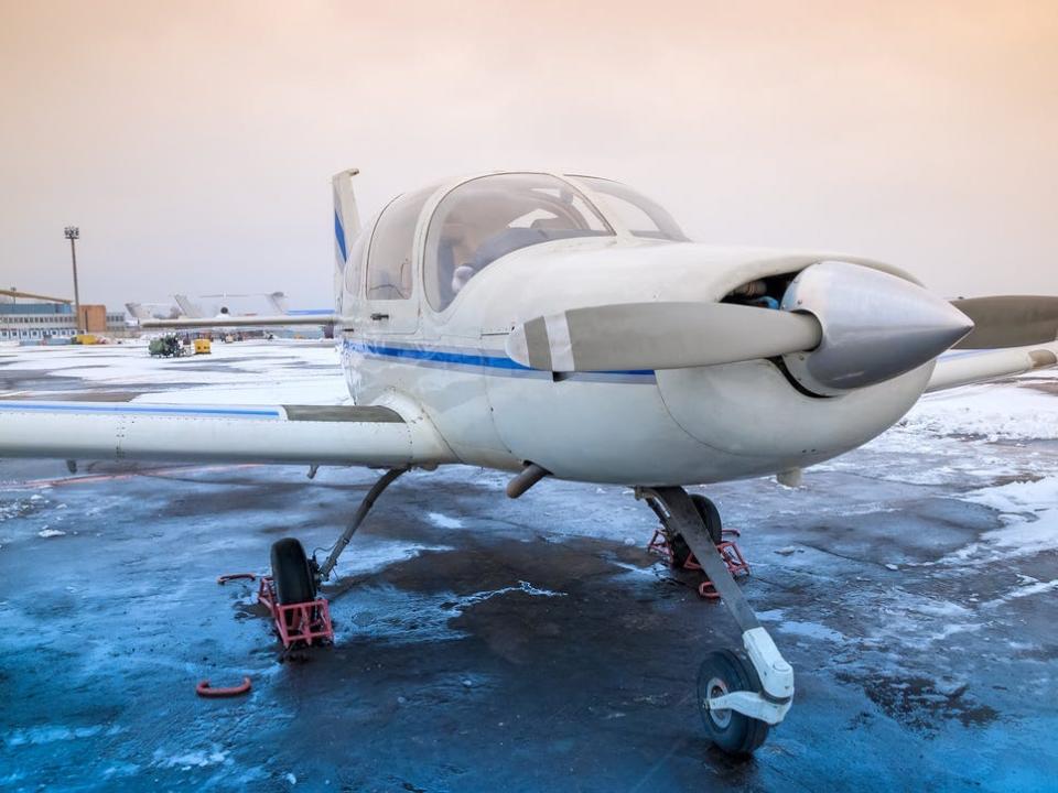 A small plane at an airport in non-flying, winter weather.