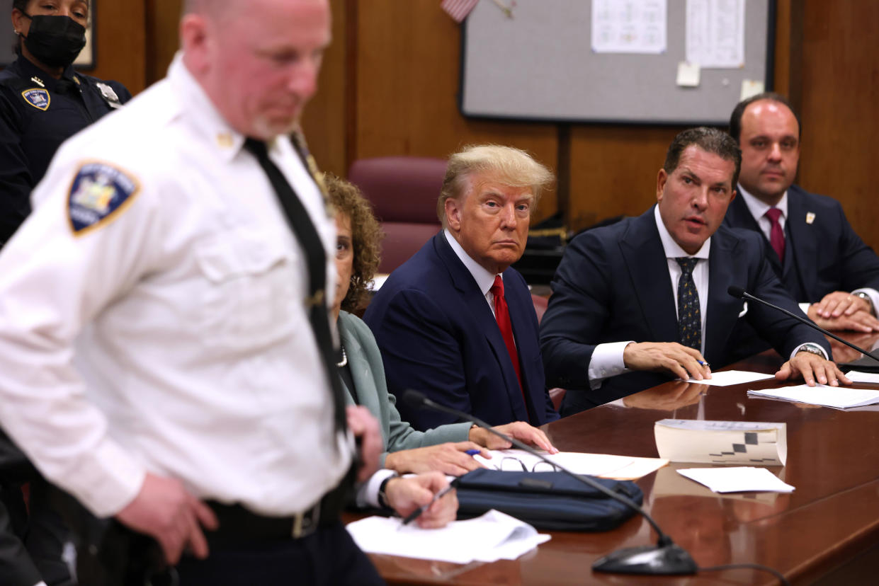 Former President Donald Trump sits with his attorneys inside the courtroom during his arraignment at the Manhattan Criminal Court on April 4, 2023, in New York City. Photographers were allowed inside the courtroom for a few minutes before the hearing started.  / Credit: Getty Images