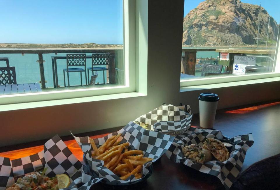 Rock Tacos customers Bruce and Joyce Hedrickson of Holland, Michigan, enjoyed the new restaurant’s view of Morro Rock and the harbor on March 24, 2023. They dined on, from left, shrimp tacos, fries and a Surf & Turf Burrito.