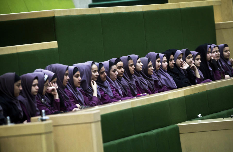 Iranian school girls observe Members of Parliament discussing a draft to limit photographer's and cameramen's access to cover parliament's open sessions in Tehran on February 27, 2013. 